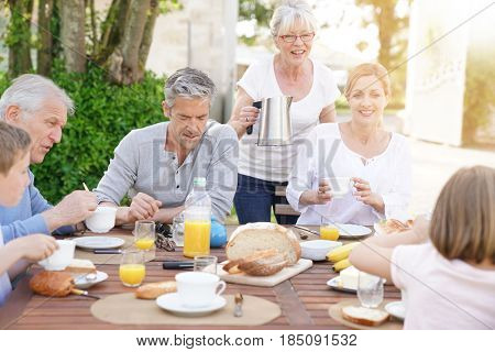 Family of 6 having breakfast together outside the house