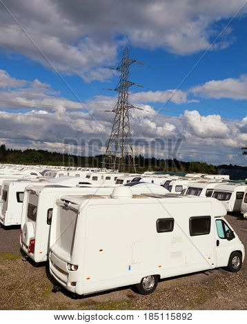 Caravans stored in rows on a cloudy day with blue sky day. With space for text.