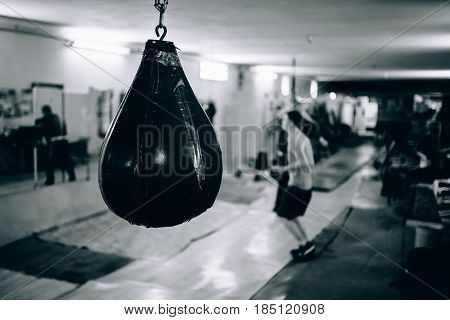 Punching bag in the gym. Against the backdrop of athletes. Gym is a cellar. Russia.