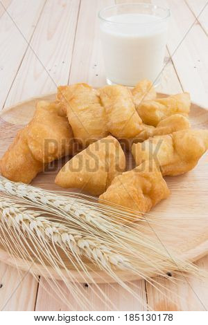 soybean milk in glass and youtiao on wood plate