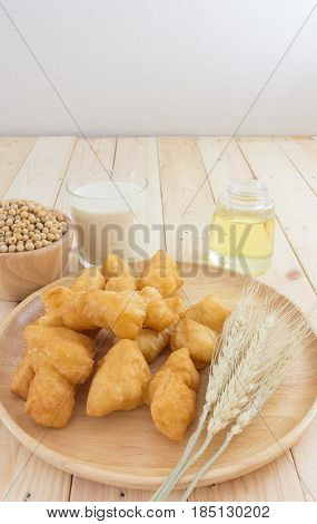 soybean milk in glass and youtiao on wood plate