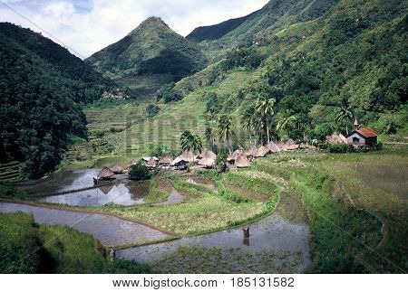 An Ifugao village stands at the bottom of a valley below the ancient rice terraces, carved into the mountains, near the city of Banaue, Ifugao Province, in the Philippines.