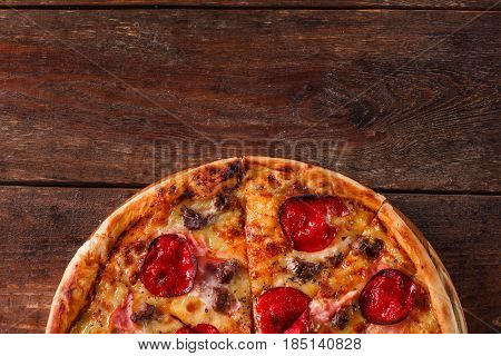 Junk food, bad habits, calories. Fresh pizza with salami, bacon and cheese on rustic wooden table, flat lay with free space for text.