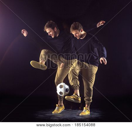 A portrait of a fan with ball on gray studio background. Freestile concept. Stroboscope shooting technique