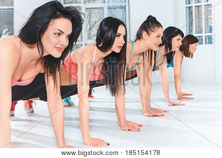 The group of fit young women training in a gym or a fitness center. Healthy and fitness concept
