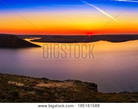 Magnificent sunset scenery on the Dniester river with colorful evening sky reflected in the water