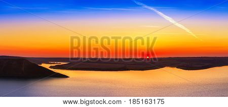 Magnificent sunset scenery on the Dniester river with colorful evening sky reflected in the water