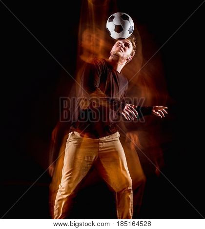 A portrait of a fan with ball on gray studio background. Freestile concept. Stroboscope shooting technique