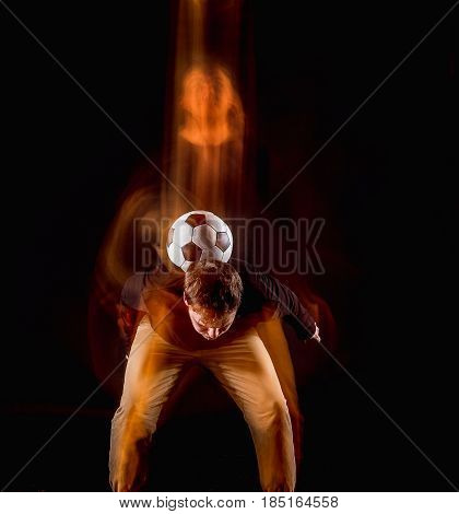 A portrait of a fan with ball on gray studio background. Freestile concept. Stroboscope shooting technique