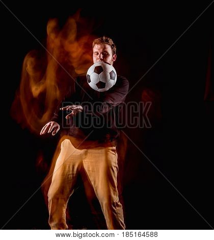 A portrait of a fan with ball on gray studio background. Freestile concept. Stroboscope shooting technique