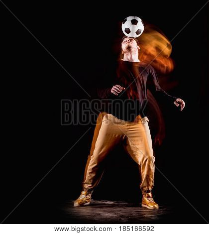 A portrait of a fan with ball on gray studio background. Freestile concept. Stroboscope shooting technique
