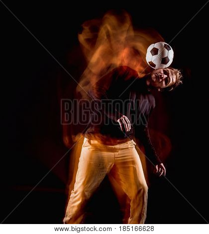 A portrait of a fan with ball on gray studio background. Freestile concept. Stroboscope shooting technique