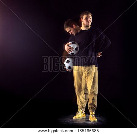A portrait of a fan with ball on gray studio background. Freestile concept. Stroboscope shooting technique
