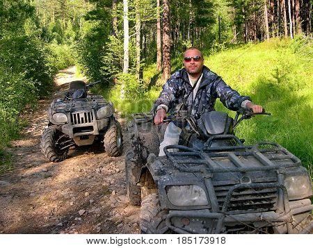 Lake Baikal, Russia - July 29, 2016: The man on ATV is riding off road the taiga