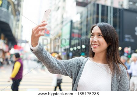 Young woman take selfie by mobile pone in Hong Kong