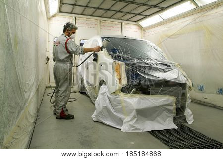 Worker Painting A Car On His Garage