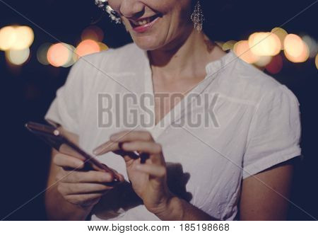 Woman using smart phone walking on street night time