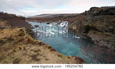 Hraunfossar Horizontal Waterfall In Icealand. Beautiful And Majestic Landscape Tourist Attraction Pl