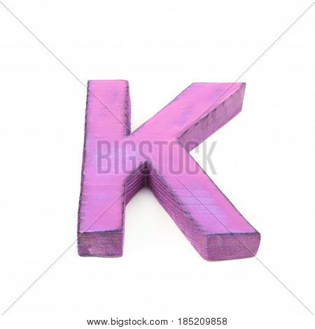Single sawn wooden letter K symbol coated with paint isolated over the white background