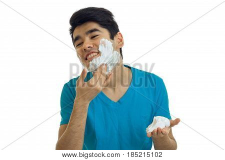 young guy strikes shaving foam on your face and laughs is isolated on a white background
