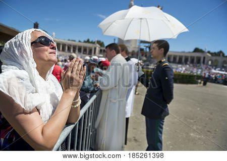 Fatima Portugal - May 13 2014: Woman praying at the Sanctuary of Fatima during the celebrations of the apparition of the Virgin Mary in Fatima Portugal.