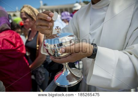 Fatima Portugal - May 13 2014: Priest holding a ciborium with sacramental bread at the Sanctuary of Fatima during the celebrations of the apparition of the Virgin Mary in Fatima Portugal.