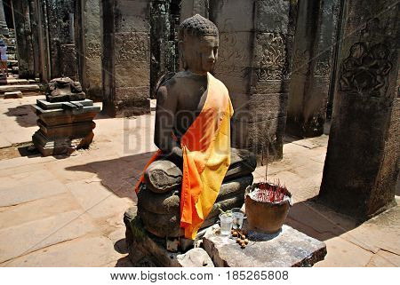 Buddhist statue in Ankor Wat. Incense and faith. Cambodia