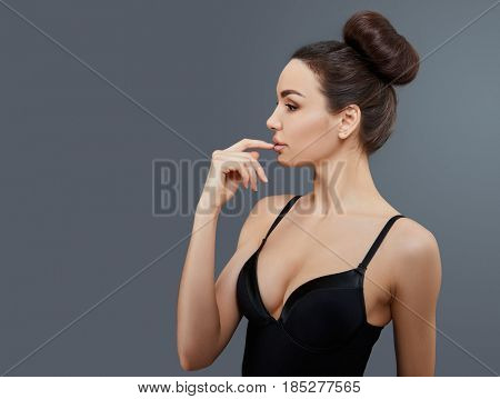 Beauty. Female portrait. Beautiful girl cheerful posing over grey background. Woman's face and hands.
