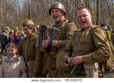Gatchina, Russia - May 7, 2017: Historical reconstruction of the battles of World War II. Soldiers sing the song of the war - Katyusha. The soldier plays the accordion.