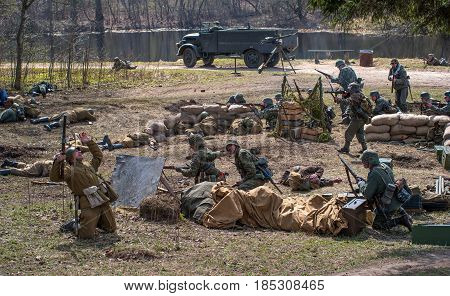 Gatchina, Russia - May 7, 2017: Historical reconstruction of the battles of World War II. German soldiers defend a mortar battery. The dead Soviet soldier falls.