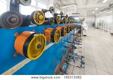 Rotating rubberized wheels of the winding machine. A lot of rotating wheels are yellow.
