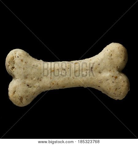 Dog biscuit on black background to connote a concept of feeding animals