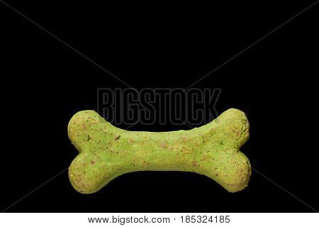 Dog biscuit on black background to connote a concept of feeding animals
