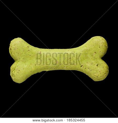 Dog biscuit on black background to connote a concept of feeding animals