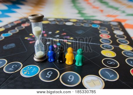Multi-colored Chips For Tabletop Game In The Form Of Little Men And An Hourglass