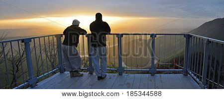 Two hikers enjoy in misty morning and sunrise on mountain.  Panoramic view on meanders of Morava river from Kablar, Serbia