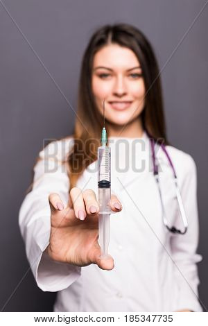 Young Doctor Woman With Syringe On Grey Background