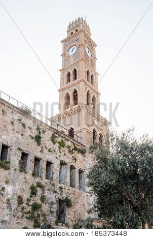 Abandoned building of caravanserai Khan al-Umdan and the clock tower Khan al-Umdan in the old town of Ako Israel