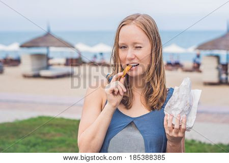 Women Eat Fried Sweet Potatoes In The Park. Junk Food Concept