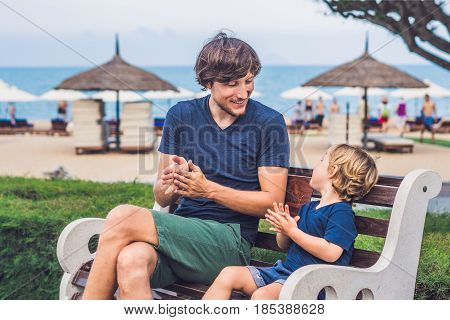Father And Son Eat Fried Sweet Potatoes In The Park. Junk Food Concept