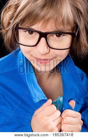 Emotional portrait of attractive caucasian little student girl with eyeglasses. Funny cute smiling child looking at camera on black background.