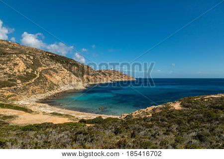 Lighthouse and beach at Revellata near Calvi in the Balagne region of Corsica with clear turquoise Mediterranean sea and blue sky