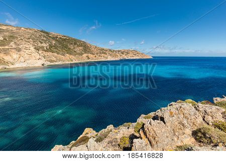 Lighthouse and turquoise Mediterranean sea at Revellata near Calvi in the Balagne region of Corsica with blue sky and rocky coastline