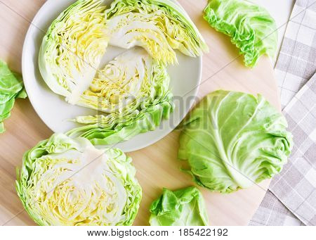 fresh green cutted head of cabbage on ceramic gray plate wooden and material background