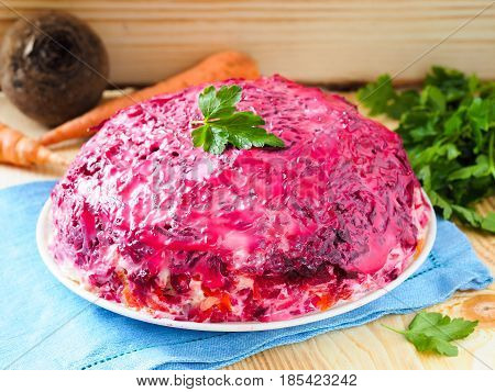 Close up view of homemade herring under a fur coat and ingredients. National festive Russian dish with beetroot. Served with fresh parsley