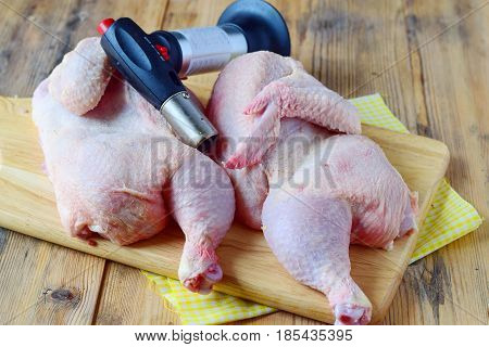 Two halves of raw chicken with flamber on a wooden cutting board. Cooking step by step. Healthy eating concept