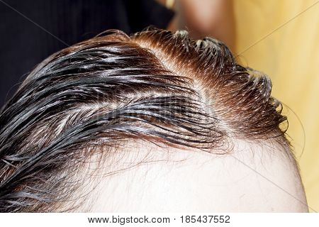 Hairdresser Marinating on hair black color Asia women.
