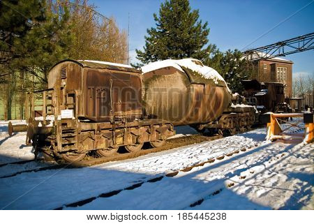 Industrial plant torpedo car train rail in winter snow ice steel rust