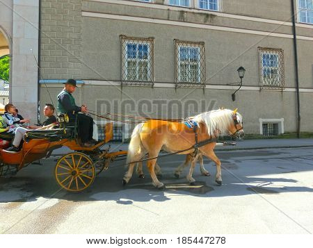 Salzburg, Austria - May 01, 2017: Central place in Salzburg city , Austria with carriages and horses at Salzburg, Austria on May 01, 2017