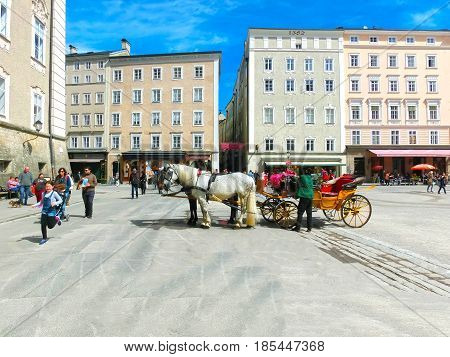 Salzburg, Austria - May 01, 2017: Central place in Salzburg city , Austria with carriages and horses at Salzburg, Austria on May 01, 2017